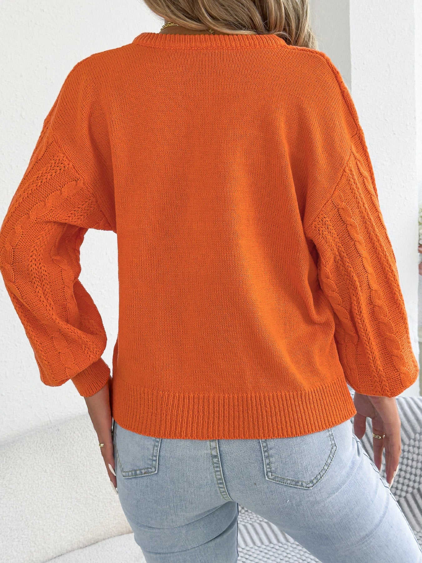 Maglione da donna con scollo a V e dettaglio a catena metallica
